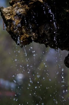 close-up on water in motion falling down on rocks, in a park