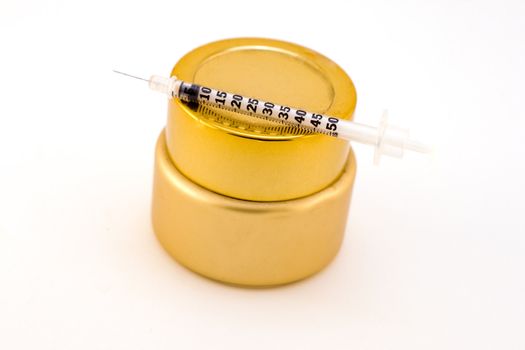 beauty product in gold jar with needle