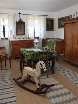 Wooden rocking horse farm house in his room.