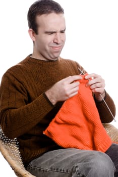 A young man is learning to knit and looks frustrated, isolated against a white background