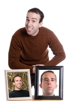 A young man is smiling and standing next to self portraits of himself, isolated against a white background