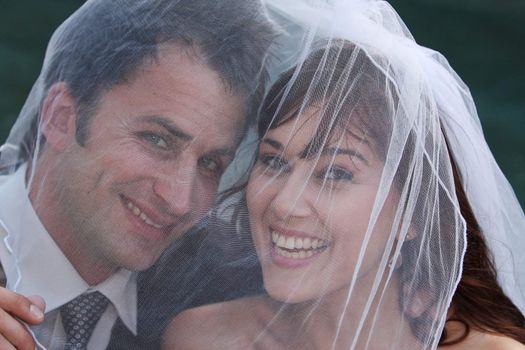 Husband and wife on wedding day under the veil