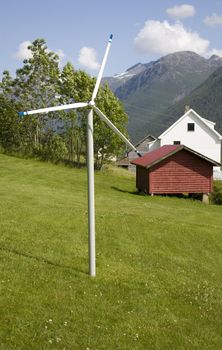 Small decorative windmill in rural summer landscape. 
