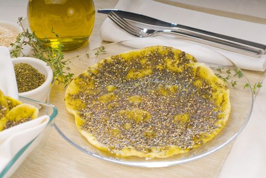 lebanese manouche or manoushe ,lebanese pizza with thyme and sesame seeds,zaatar, and extra virgin olive oil on top