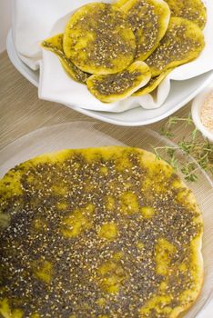 lebanese manouche or manoushe ,lebanese pizza with thyme and sesame seeds,zaatar, and extra virgin olive oil on top