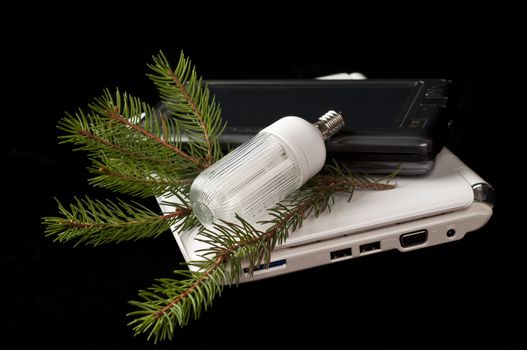 netbooks and energy saving light bulb on black background