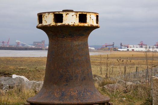 Capstan on old quayside at Portishead with Avonmouth docks on the horizon