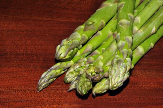 some asparagus on a table of dark wood