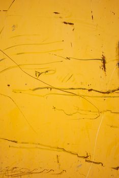 Rusted scratches and scrapes on a yellow painted wall