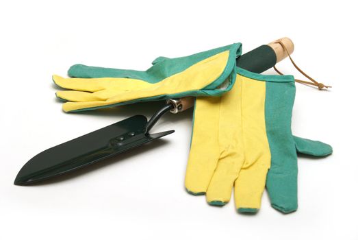 A gardeners pair of gloves and spade shovel are isolated on white.