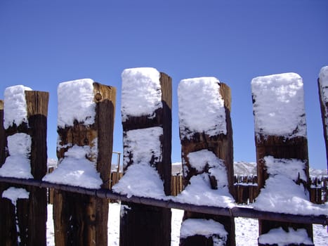 Snow covers wood fence in Mojave Desert USA