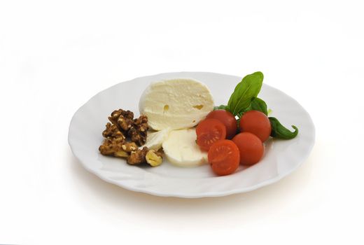 Mozzarella cherry tomatoes and walnuts on white background