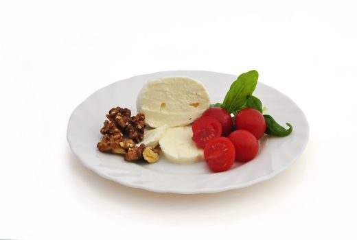 Mozzarella cherry tomatoes and walnuts on white background