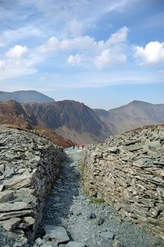 A narrow walled path in the mountains of the Lake District, England