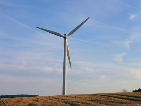 Alternative energy futuristic vision - wind turbine in a wheat field