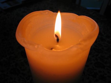 Big blowing beautiful orange candle isolated black background