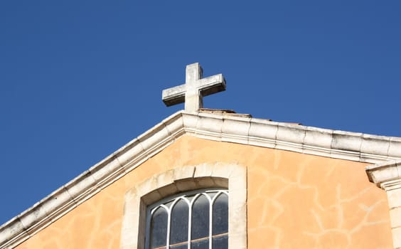 Cross on the top of a christian church with blue sky background