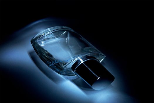 Blue perfume bottle on black background