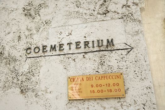 Sign with arrow directing towards coemeterium in Rome, Italy.