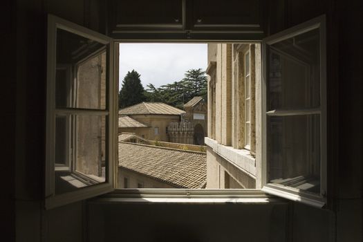 Looking out open window with view of rooftops in the Vatican Museum, Rome, Italy.