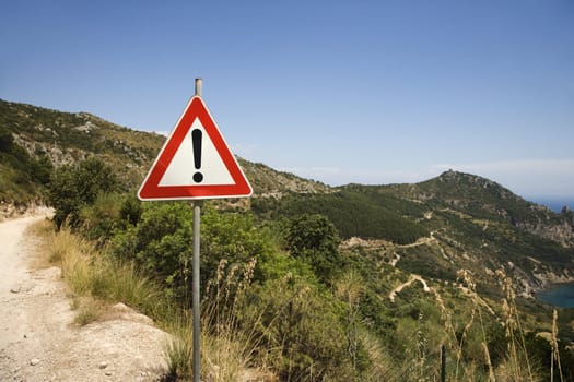 Caution sign on coastal dirt road.