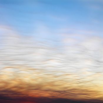 Wispy clouds in sunset colored sky.