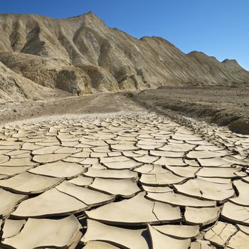 Arrid landscape in Death Valley National Park with dry, cracked ground.