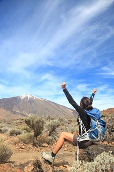 Hiking. Happy woman hiker with her arms raised up in the blue sky with lot's of copy space. From Teide, Tenerife