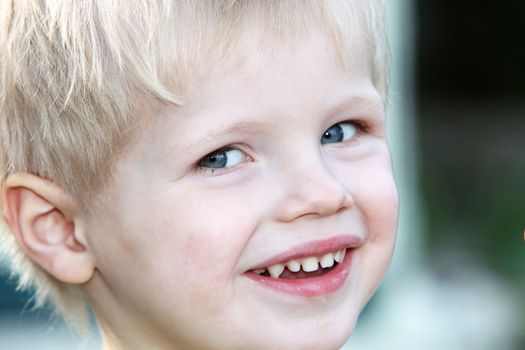 Young, happy blond boy laughs - Close up