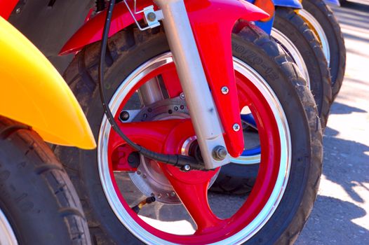 closeup of row of front scooter wheels