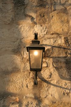 An old antique light fixture on a stone wall
