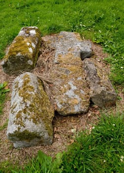 Old medieval stone cross, lying broken and fallen on the grass at Killevy Churches, County Armagh, Northern Ireland