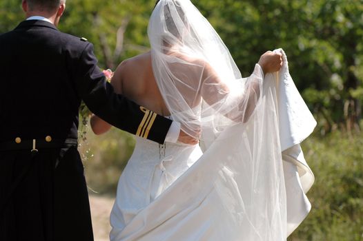 Groom holding the dress for his wedding bride.