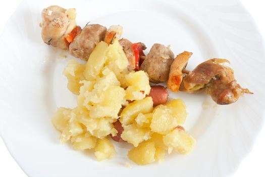detail of baked pork kebab with potatoes on a dish