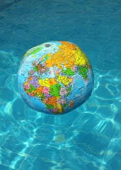 Inflatable ball on a swimming - pool water ,
globe - designed  and colorfull.
 Water is brihg, clean and shalliow.
