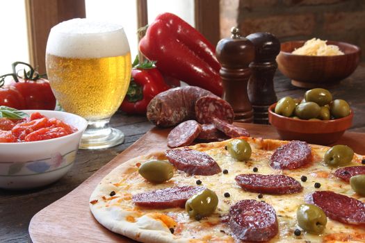 Pepperoni pizza, with a glass of beer and ingredients