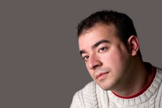 A young man thinking about something isolated over a silver background.