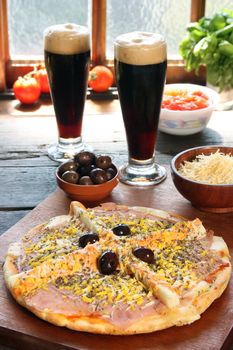 Palmetto pizza with two glasses of beer and ingredients