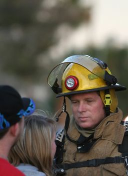 A fireman comforts a family whose house is on fire