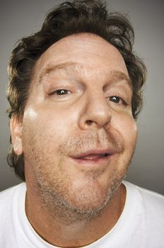 Confident Goofy Guy with Obnoxious Expression Against a Grey Background.