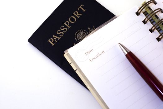 A travel notepad with pen and passport