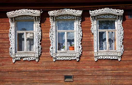 Three windows from old wooden rural wall