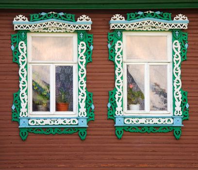 Two windows from old wooden red wall