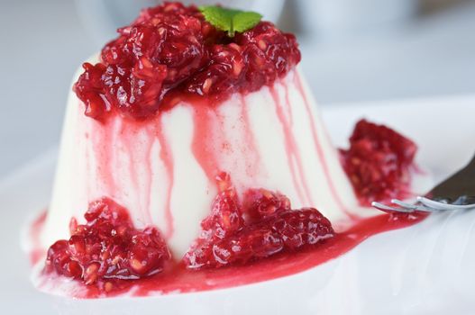 Panna cotta made with lemon and buttermilk and raspberry sauce