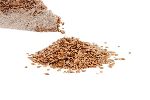 Pile of linseed being poured from a bag on a reflective white background