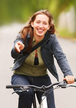 The laughing young girl going from a hill on a bicycle.