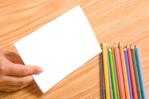 Kids hand holding blank paper for message. Copy space