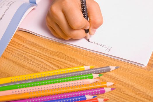 Girl doing her homework by writing in notebook.