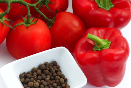 Tomatoes, red pepper and spice on the white background.