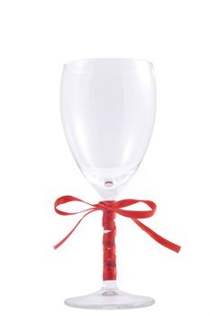 glass of wine and red ribbon over white background